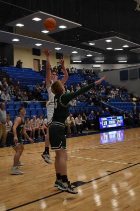 Senior Bode Gallagher tosses a shot over the head of an opposing player.
