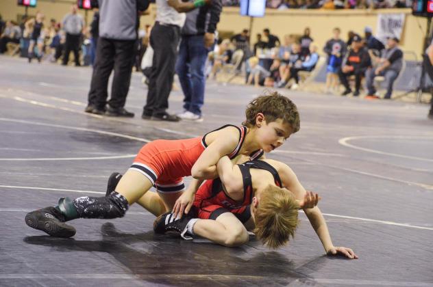 Hunter Larsen maneuvers his opponent to the mat. Photo by Erin Dudgeon.