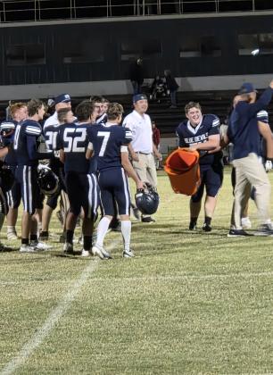 Senior Sam Lindsey sneaks up on Coach Bobeck after the win against Mountain View