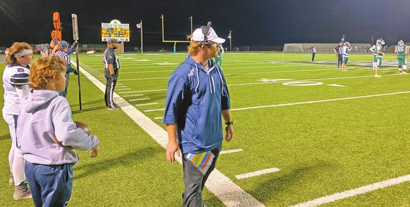 ABOVE: Cordell seniors get together for one last post-game photo after the team’s 49-22 loss against Thomas. LEFT: Acting coach Dillon Ball watches the action. Ball was filling in for Zane Trammell, who had to miss the game because he contracted COVID-19. COURTESY PHOTOS BY CHARLINDA OGLE