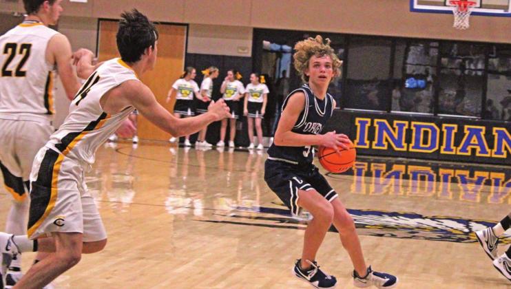 PHOTOS BY FLORA WALTERS RIGHT: Freshman Kray Rogers quickly changes course to shake off Trojan opponents. The boys went 1-4 on the week. TOP: Freshman Ellie Willard shoots a free throw. Willard lead her team in scoring last week.