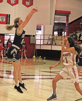 ABOVE: Senior Mckenzy Isbell attempts to shoot a 3-pointer over the head of a Carnegie Lady Wildcat. RIGHT: Junior Blaine Larsen soars through Carnegie’s defenses and up to the hoop. PHOTOS BY FLORA WALTERS
