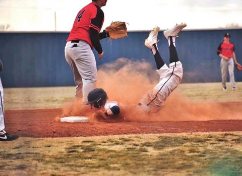 Senior Parker Johnson slides onto the base safely. The baseball team won three games last week. PHOTOS BY CARLIE BANKS