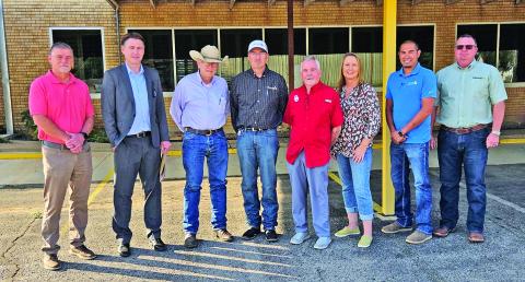 CKenergy CFO Travis Smith, City of Cordell attorney Shane Regier, CKenergy attorney John Garland and CEO Clint Pack, Cordell Mayor Phil Kliewer, Cordell Interim City Manager Vicki Hagerman, CKenergy Director of Operations Blake Scott, and Rates &amp; Marketing Director Brian Coker stand in front of the former CKenergy office building