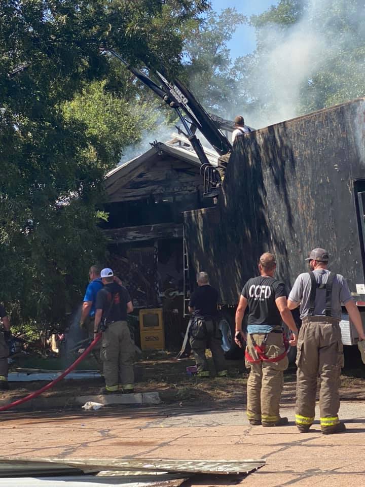 Firefighters work to remove parts of the roof.
