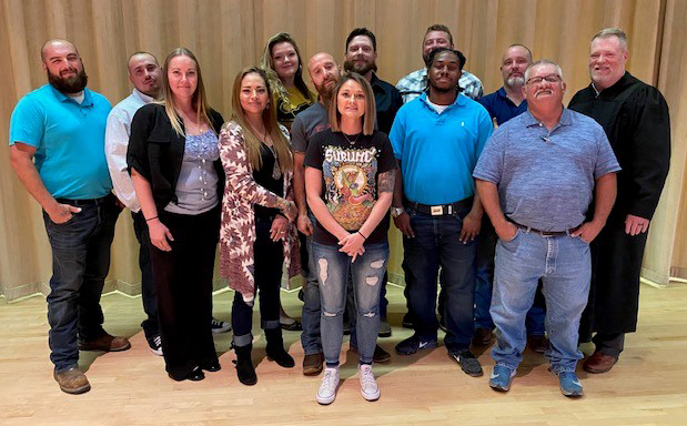 This Washita-Custer County Treatment Court Program saw 12 of its members graduate. Pictured above are all of them alongside Associate District Judge Christopher Kelly (far right).
