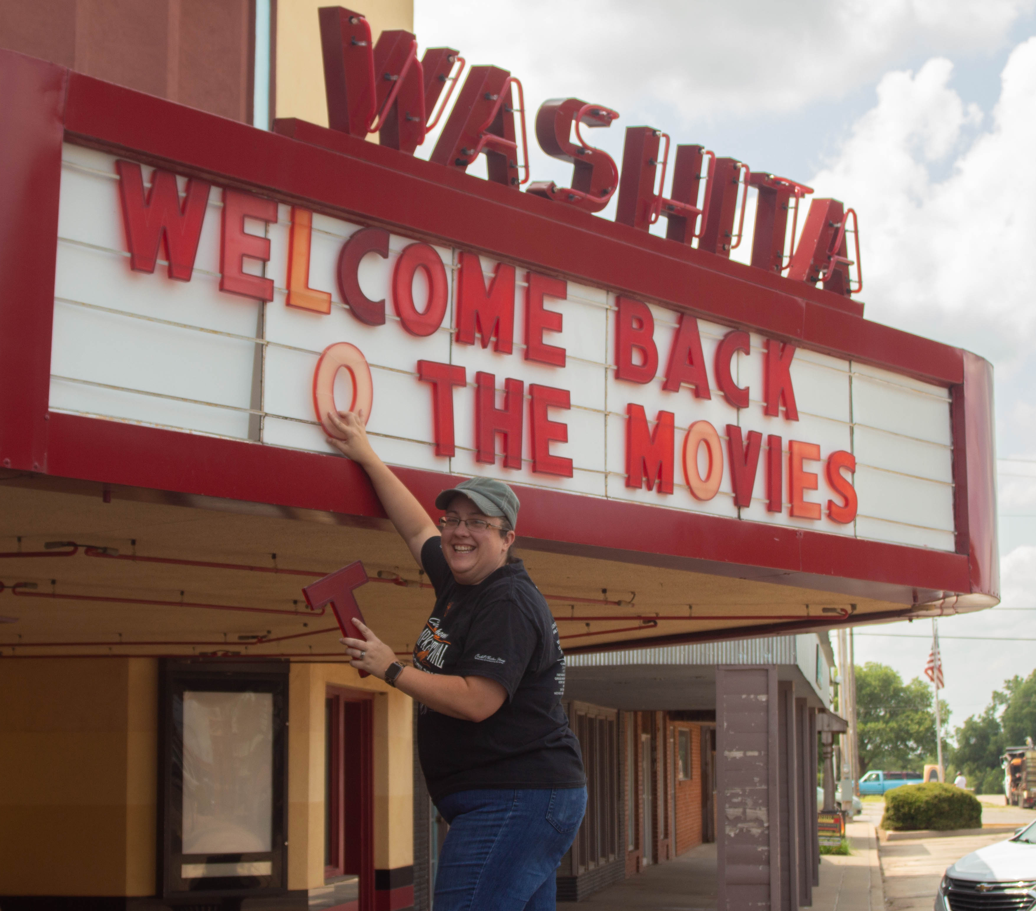 Chamber Secretary Sarah Lau climbs up to change letters on the marquee.