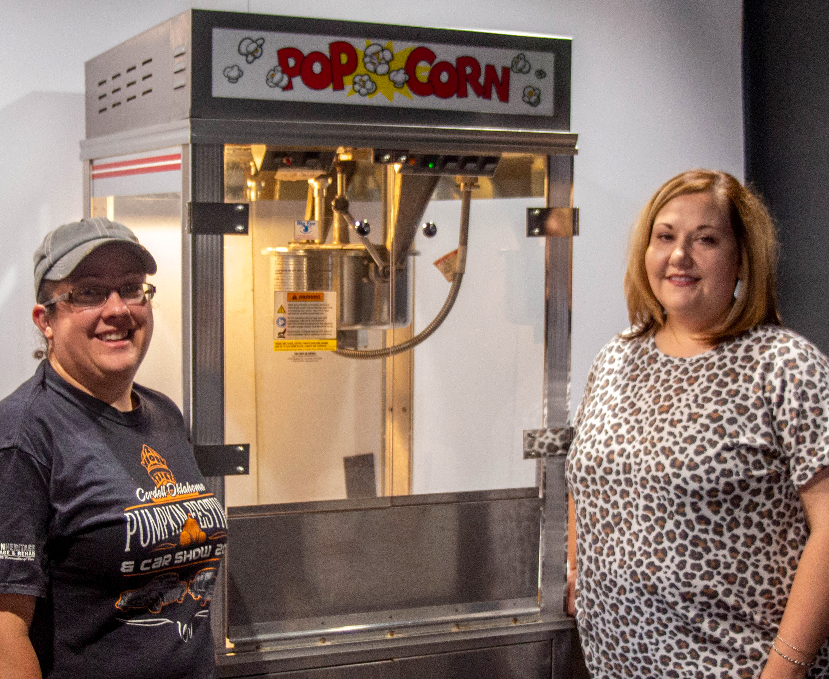 Sarah Lau and Chamber Director Heather Flores inspect the popcorn machine to ensure it is ready to go.