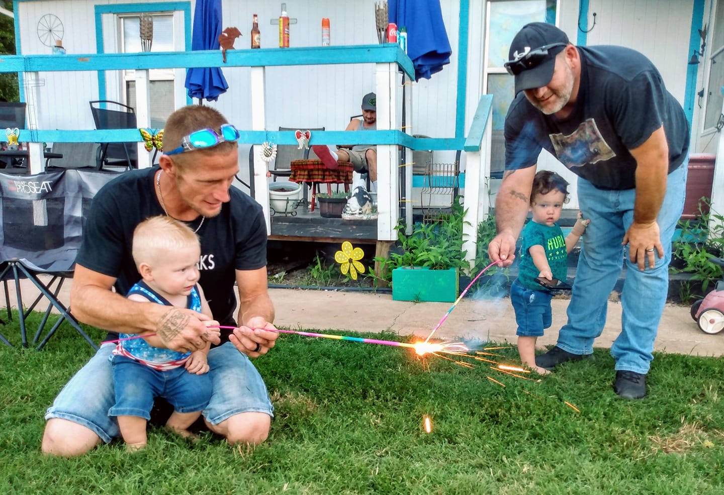 John Harrison (left) and Everett Harrison (right) help give their sons, Renegade and Tyler respectively, their first ever sparkler experience. 