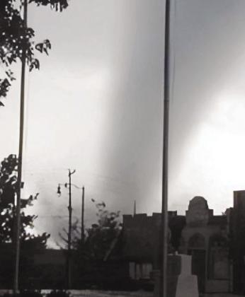 Above: A destroyed home on 9th Street displays a sign saying “Together We Will Stand.” Top right: Then Police Chief Gary Coburn’s home located on Fleming Street. Lower Right: Beacon Staff Photographer Dickie Elston snapped this photo of the tornado as it approached Cordell from the southwest. BEACON FILE PHOTOS