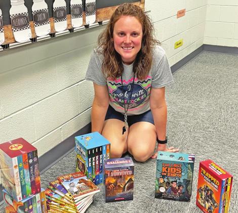 Above: Third grade teacher Anna Feltman with the books purchased for her classroom through the Academic Foundation grant.
