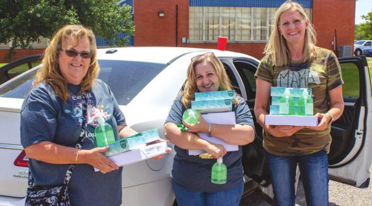 First grade teachers Lisa Griffith (left), Debra Hougland (center), and Robbi Regier (right) carrying out some of the school supplies provided by Equity Bank. PHOTO BY HECTOR LUCAS