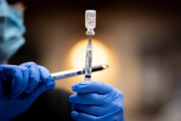 A health care worker fills a syringe with the COVID-19 Pfizer vaccine. (Whitney Bryen/Oklahoma Watch)