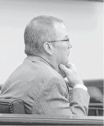 Brad Overton listens to discussion during a school board meeting.