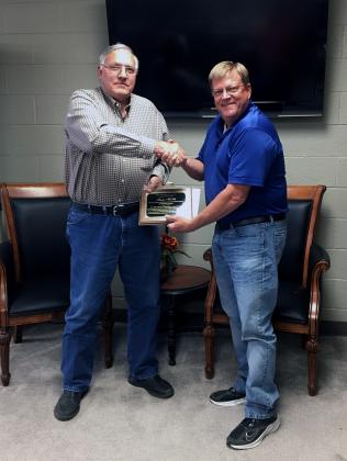 David Thain (right) hands Ronnie McKee (left) a plaque in recognition of McKee’s 12 year history on the school board.