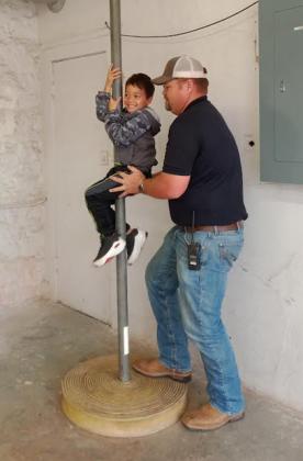 A student makes their way down the fire pole with the assistance of firefighter Levi Jones.PHOTO BY HEATHER FLORES