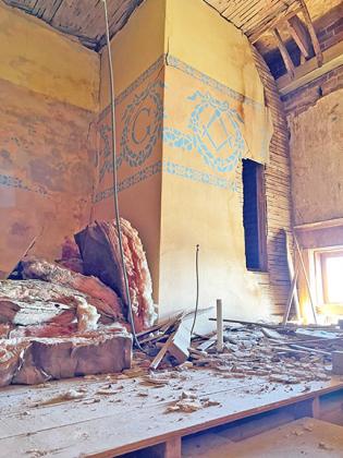 Although parts of the upper floors are in disrepair, time has spared many historic details, such as these Masonic symbols painted around the top of the walls.