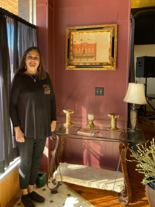 Julie Barnett standing next to an original painting of the Opera House Mall.