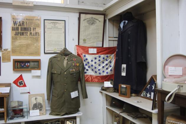 Military and war-related memorabilia are just a small portion of the multitude of artifacts displayed in the Washita County Historical Museum. The museum Board of Directors and volunteer Hostess Callie Beech-Seibold are hopeful that the community will visit the museum and generate interest so that the museum can remain open indefinitely. Photo by Brooklynn Peek