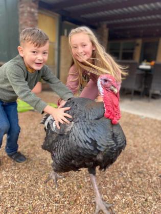 Whitten and Waverly Schneberger with their pet turkey, Tommy.