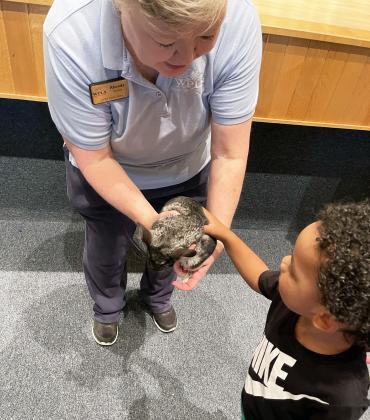 Cordell Librarian Rhonda Schmidt holds a chinchilla for Imre Jordan to pet