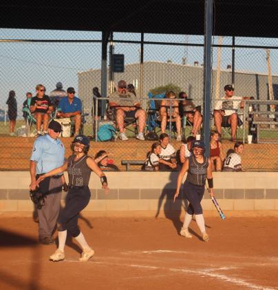 Ramsey King, #3, cheers on her teammate, #13 Tatym King, as she crosses the home plate safe