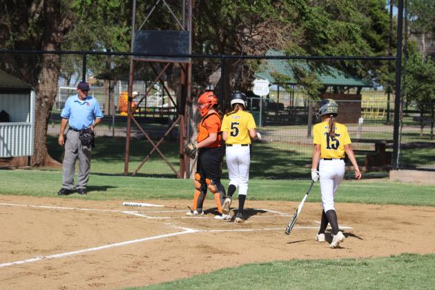 Kinley Pruett #5 exits the batters box as Lily Woodson #15 steps up to the plate.