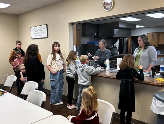 Danielle Shaw and Jalee Victory serve cocoa to students and families