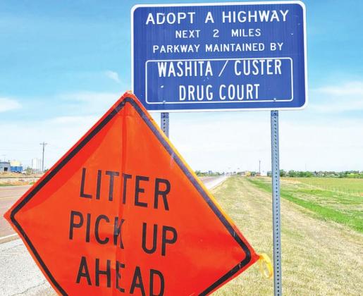 LEFT: A sign designates the length of highway that has been adopted by the Treatment Court and orange warning triangles alert drivers to their presence on clean