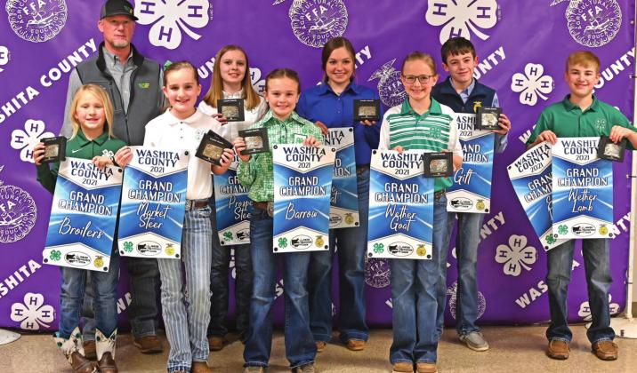 Washita County Junior Livestock Show Grand Champion Exhibitors displaying their banners from the Fair Board and the trophy buckles from Western Equipment. L-R back row: Gary Lynn Randall-Western Equipment, Aubrey Sturgeon, Madison Church, Luke Rozell and Clay Randall. L-R Front Row: Cassi Ray, Bentlee Lester, Sayde Allen and Kinley Pruett. Not Pictured: Colt Randall. CONTRIBUTED PHOTOS
