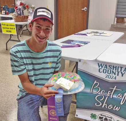 KORBEN GOSSEN WITH HIS WINNING DECORATED CAKE AT THE WASHITA CO. FAIR