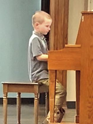 Isaiah Huntzinger, Cordell, plays at the Corn Heritage Village.