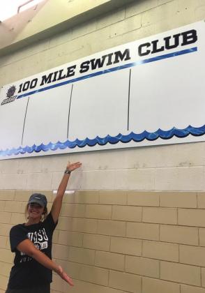 SWOSU graduate student Summer Pennington shows the new wall of fame for the 100- and 200-mile swim clubs at SWOSU.
