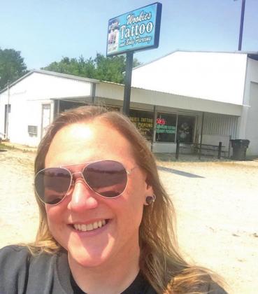 Rachel Jones stands in front of her tattoo shop when it was based in Mannsville. Jones is opening her shop in Cordell, and plans to have a blessing box in front of it. CONTRIBUTED PHOTO