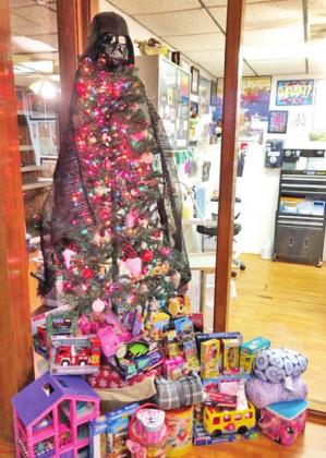RIGHT: The Christmas tree at Wookies Tattoo is surrounded by gifts that have been donated to the toy drive. Patrons can receive tattoo certificates in exchange for their donations. PHOTO BY RACHEL JONES