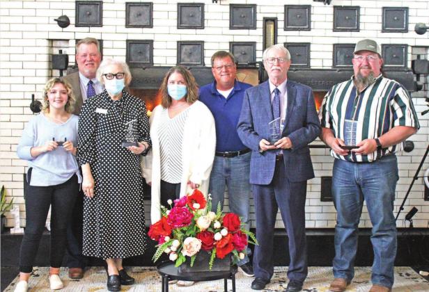 RIGHT: The cover of the program for the banquet BELOW: L-R Community Service award recipient Flora Walters, past Chamber president and co-emcee of the evening Judge Christopher Kelly, Community Award recipient representatives Gayle Wilcox and Cricket Moore, Chamber director and co-emcee David Thain, Business of the Year recipient representative Dr. Bob Abernathy, and Cordell Beacon and Great Plains Bank Person of the Year Alan Newman. CONTRIBUTED PHOTOS