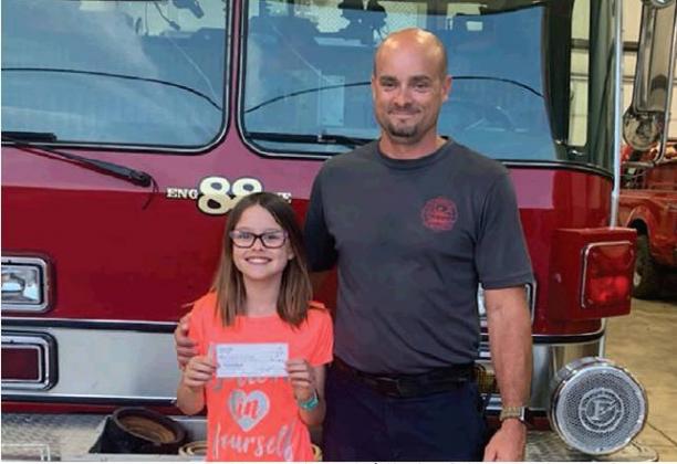 Alee Syfert, left, presented a check for $300 to Jason Dudgeon with the Cordell Fire Department. Photo courtesy of Jason Dudgeon.