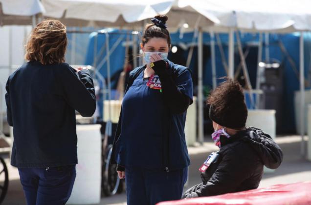 Nurses are seen at the emergency room entrance at OU Medical Center on March 28 where patients were being evaluated before entering the building. Whitney Bryen | Oklahoma Watch