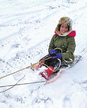 LET IT SNOW AND SNOW !!Aubrey Vela holds on tight as she gets pulled on the sled.