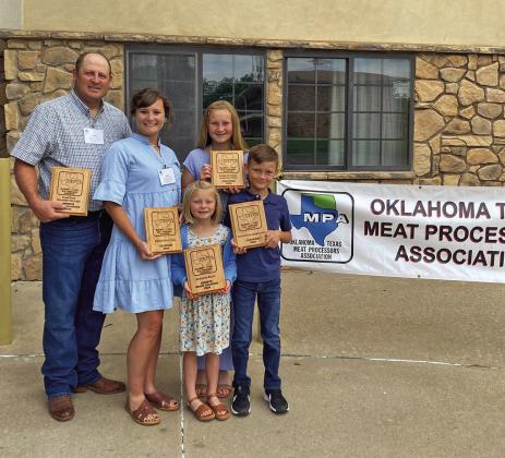 Keith Schneberger, his wife Erin and their children Waverly, Whitten and Wren proudly display winning plaques from the Cured Meat Competition at the Oklahoma-