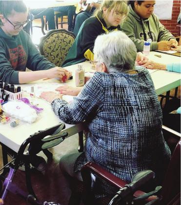 WTC Biomedical Academy students Lexis Parkhurst, Elyse Busby and Khate Solis painting residents’ fingernails during a Smile Campaign stop at Cordell Christian Home. Photo courtesy of Sarah Hirschman.