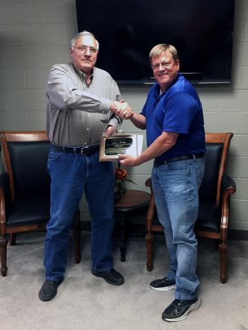 David Thain (right) hands Ronnie McKee (left) a plaque in recognition of McKee’s 12 year history on the school board.