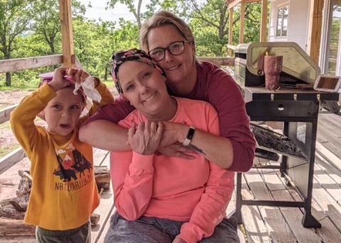 Dana Nowlin, center, is hugged by Alex Thomison’s grandmother Wendy Robb as they pose for a photo with Nowlin’s grandson. CONTRIBUTED PHOTO 