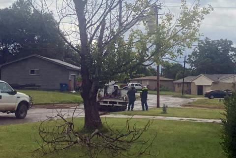 A fallen tree branch in the yard of one of Meyer’s nearby neighbors. City workers can be seen in the background repairng electric lines. PHOTO BY BETH GROVES MEYER,