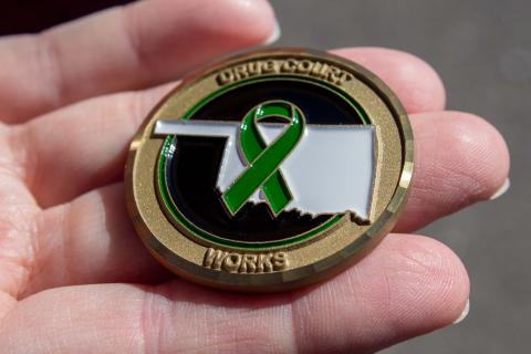 Participants of the Washita-Custer County drug court receive this coin upon graduating from the program. Around the coin is the motto of all drug courts along with the green ribbon that symbolizes Judge Ellis Cabaniss who was the Associate District Judge in Washita County that started this drug court.