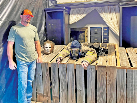 Firefighter Jason Dudgeon shows off the “Halloween” themed room. PHOTO BY BROOKLYNN PEEK