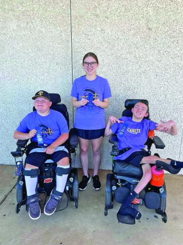 Cash Boston, Lani Woodson, and Trapper Hughes show off their first place ribbons after the Special Olympics bowling competition in Mustang