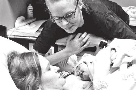 LEFT: Mariah Hanson leans over and watches Tori Ervin with her newborn baby. Hanson provided Ervin with emotional and physical support as a doula. CONTRIBUTED PHOTOS BY MARIAH HANSON