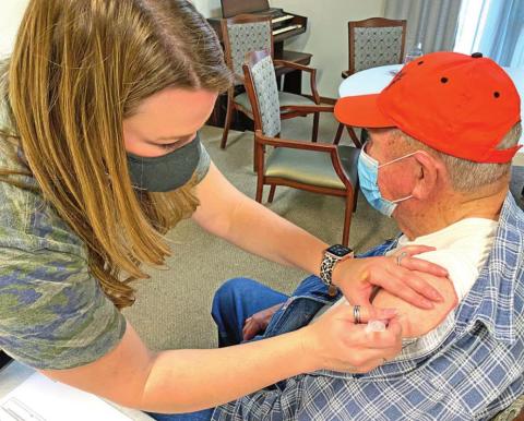 Kelsey Thompson, a COVID-19 nurse with the Oklahoma State Department of Health, gives a vaccination shot to Charlie Sappington at Baptist Village Monday afternoon. Sappington said he wasn’t worried about receiving the COVID-19 vaccine. Thompson said Cordell first responders also were scheduled to receive the shot on Monday. PHOTO BY THOMAS R. MARTINEZ
