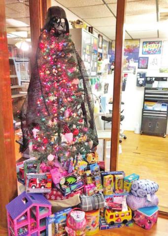 RIGHT: The Christmas tree at Wookies Tattoo is surrounded by gifts that have been donated to the toy drive. Patrons can receive tattoo certificates in exchange for their donations. PHOTO BY RACHEL JONES